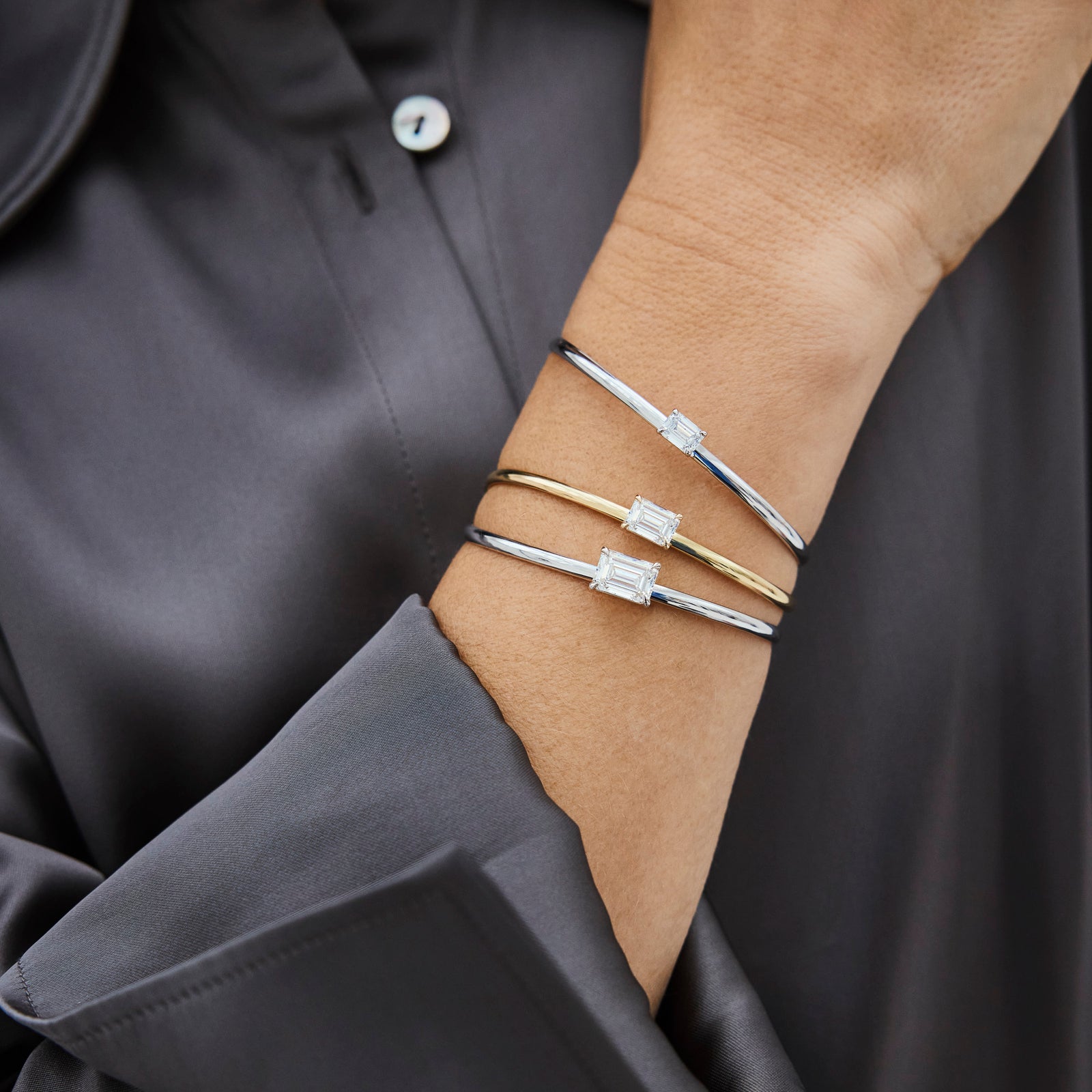 Close-up of a hand wearing a gold bracelets with lab-grown diamonds in a square design