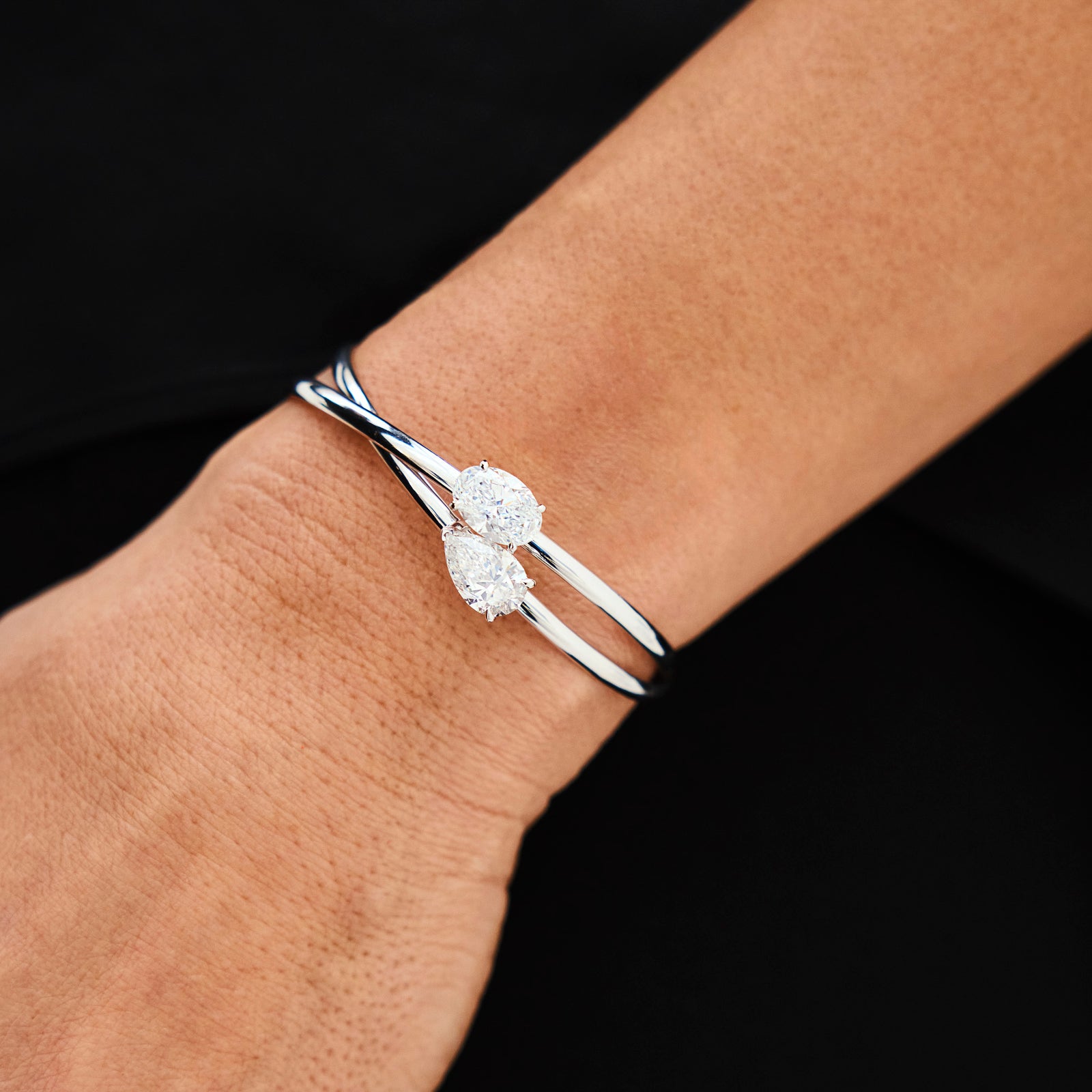 Two lab-grown diamond bracelets on a hand